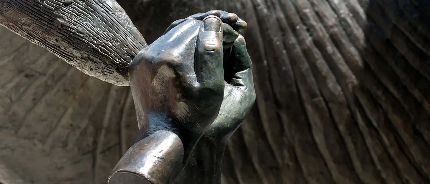Hands clasping the tip of the ram horn sculpture by the Student Commons at v.c.u.
