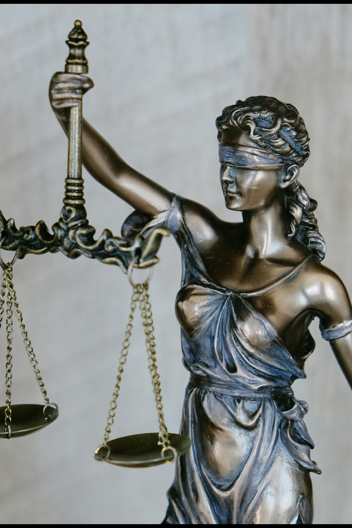 Image of a metal statue of lady justice holding scales