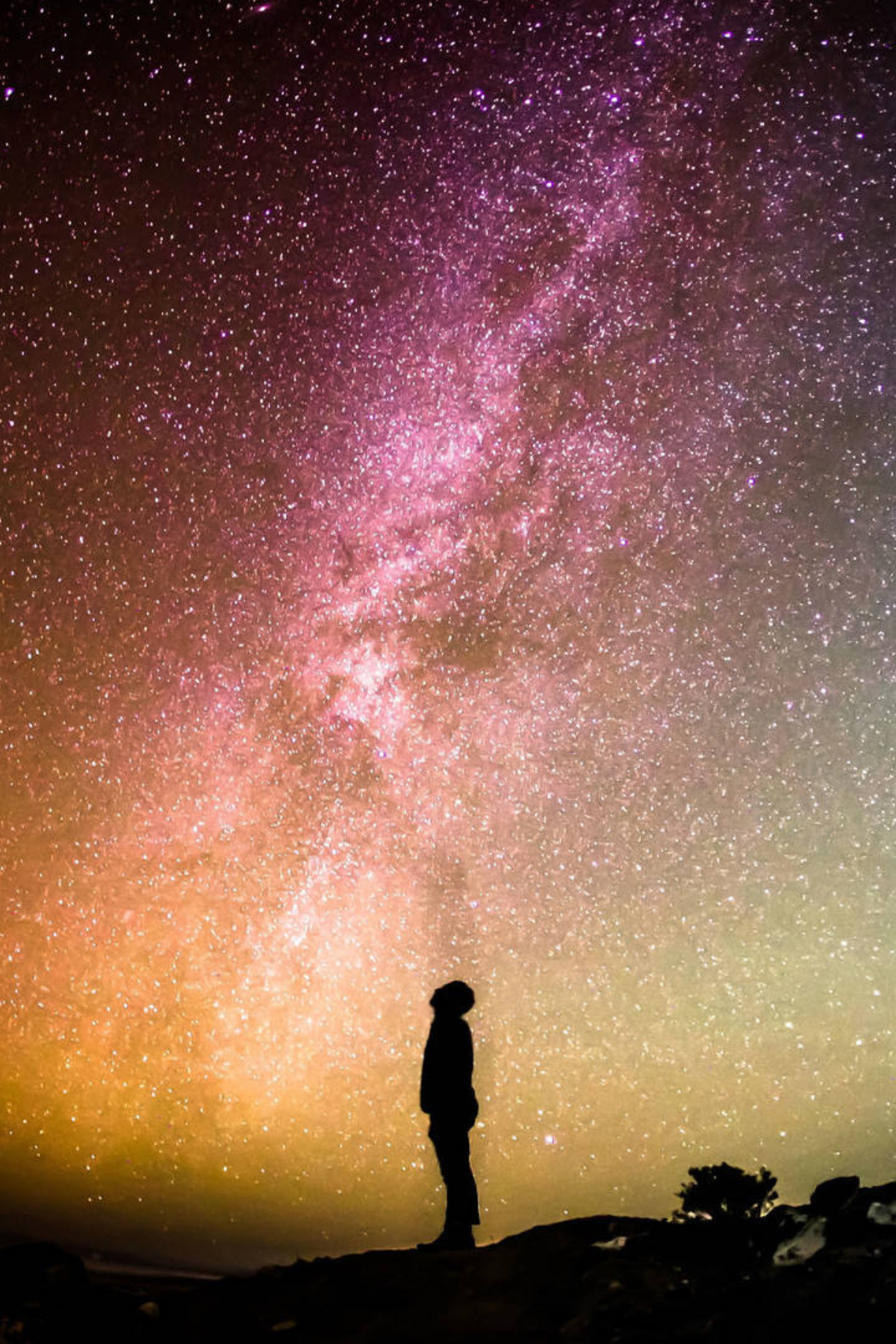A man looking up at the galaxy