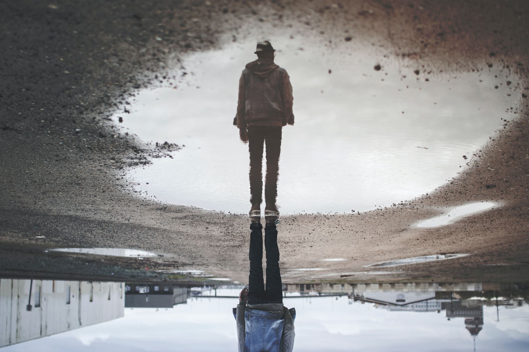 A man and his reflection in a puddle but upside down
