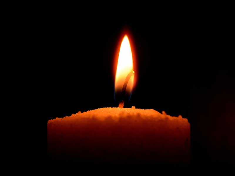 a lone candle burning in the dark